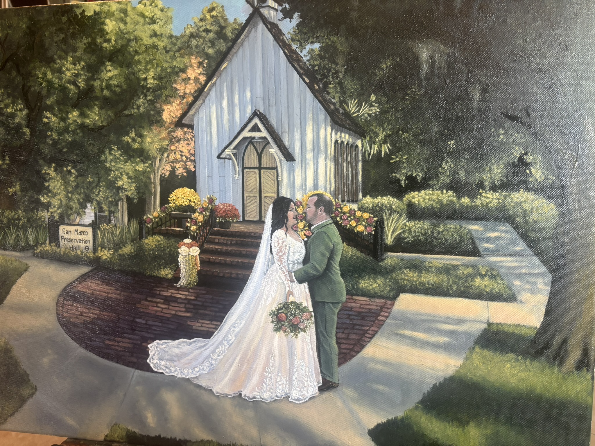 Live painting of a couple in front of a white chapel