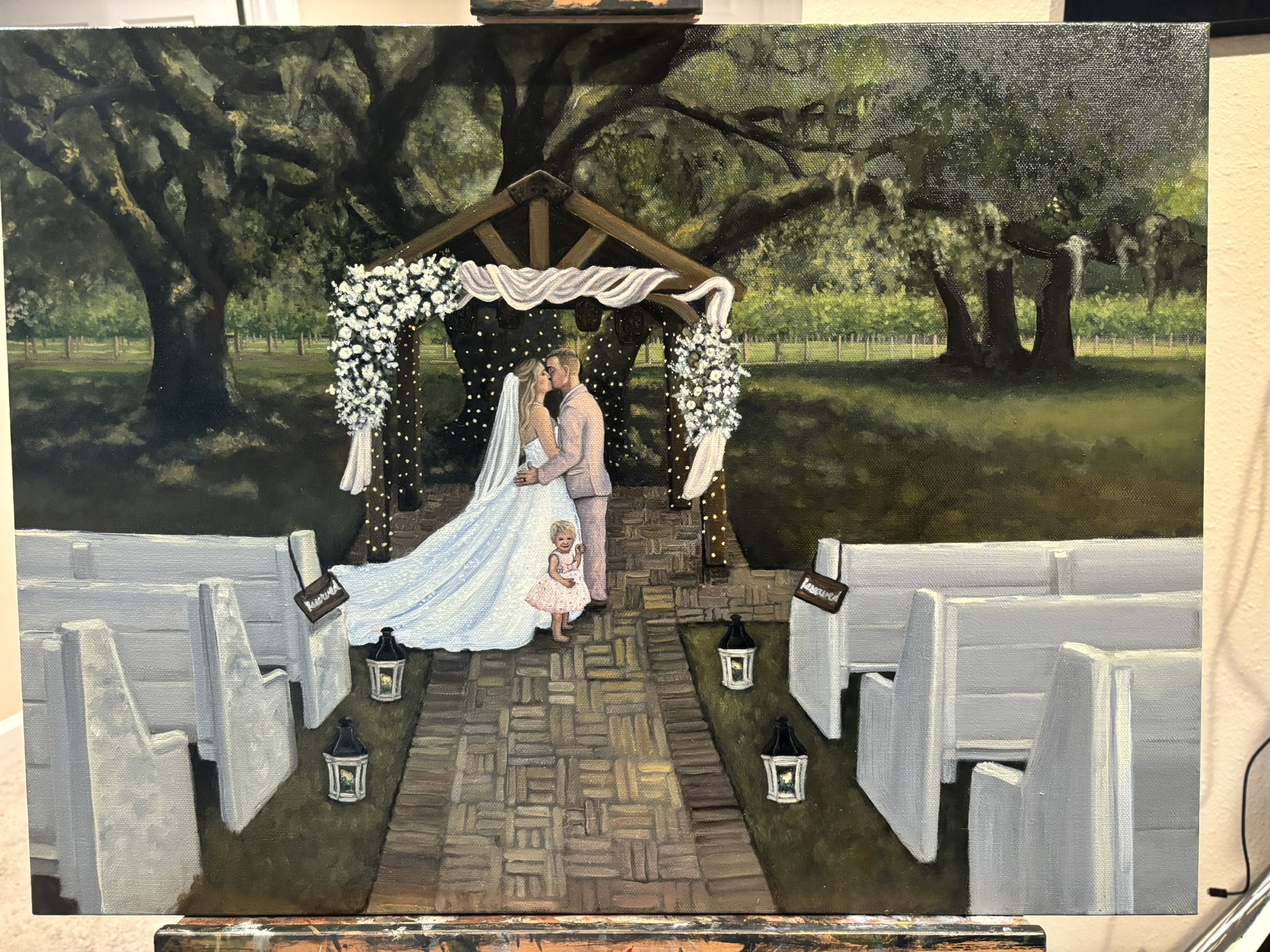 Live painting under an oak tree arch with a flower girl