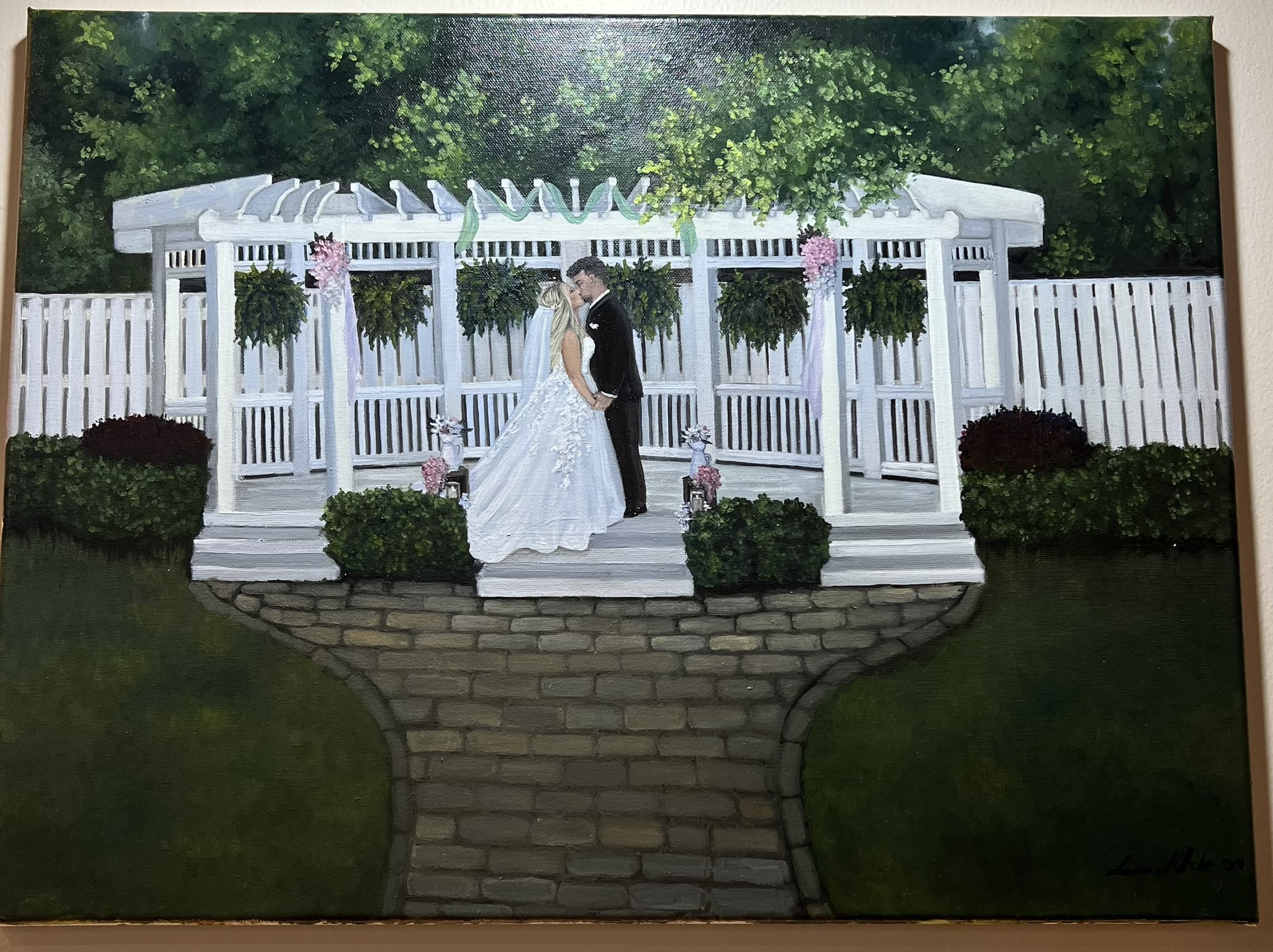 Live painting of a couple kissing under a white garden pergola